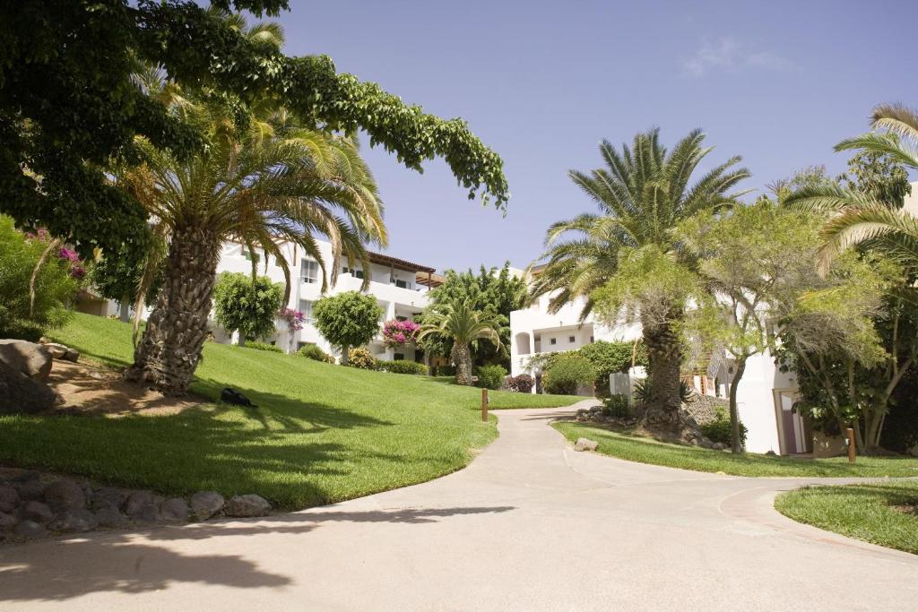 a driveway with palm trees and houses at ROBINSON ESQUINZO PLAYA - All Inclusive in Morro del Jable