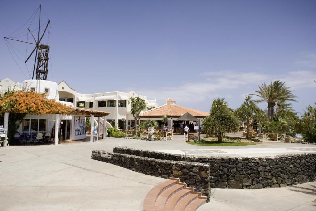 a resort with a stone wall and a building at ROBINSON ESQUINZO PLAYA - All Inclusive in Morro del Jable