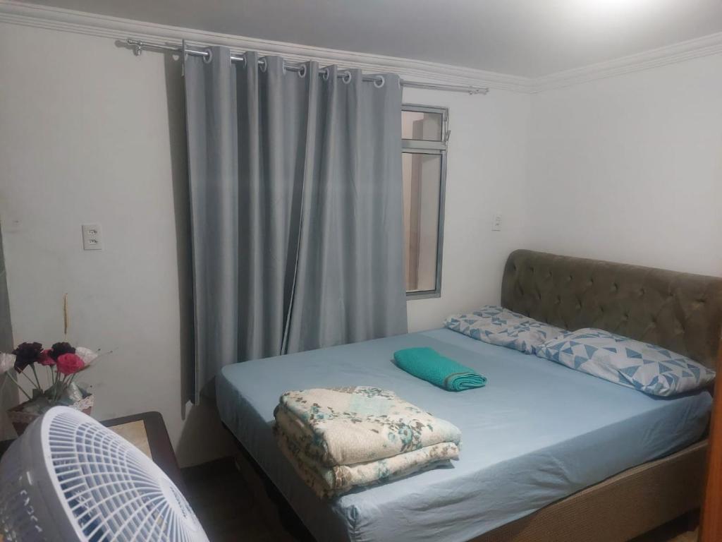 um quarto com uma cama e uma janela com uma ventoinha em Casa simples e aconchegante / Banho quente em Contagem