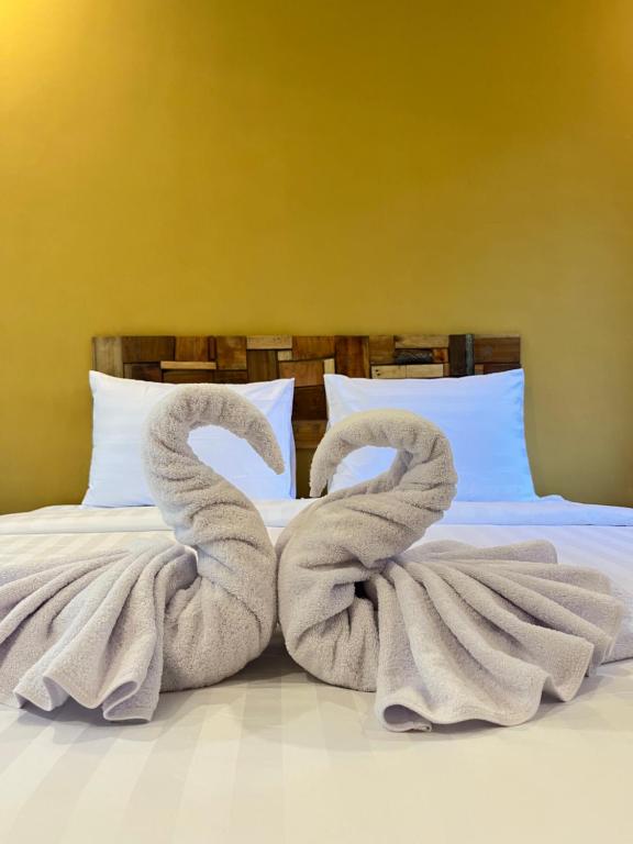 a bed with two towels shaped to look like swans at BAMBOO OASIS in Ubud