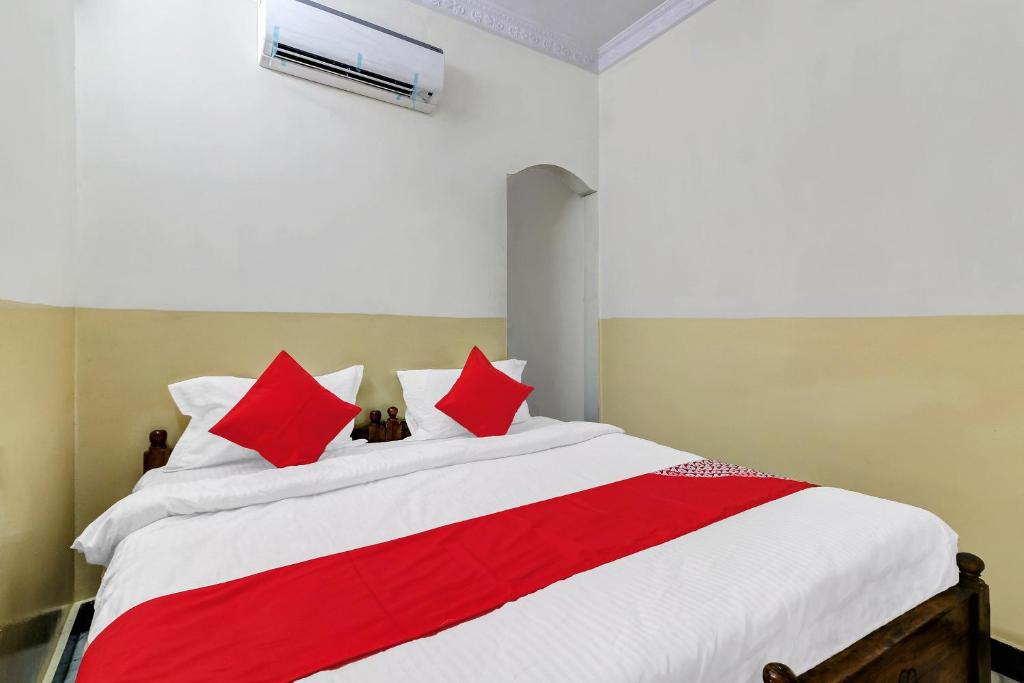 een slaapkamer met een groot bed met rode kussens bij OYO Suraj Residency in Warangal