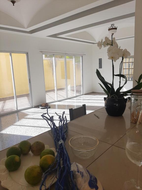 einen Tisch mit Limetten und eine Vase Blumen in der Unterkunft Habitación con balcón en una Mansión in Tegucigalpa