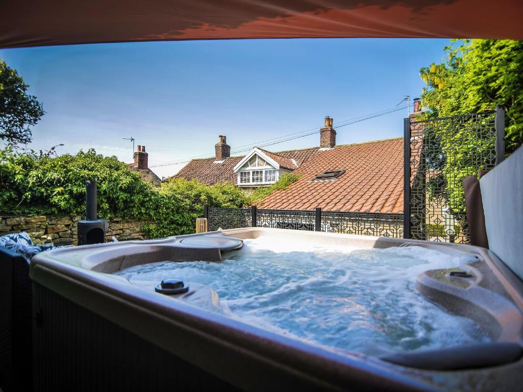 a hot tub in the backyard of a house at Snowdrop Cottage in Bulmer