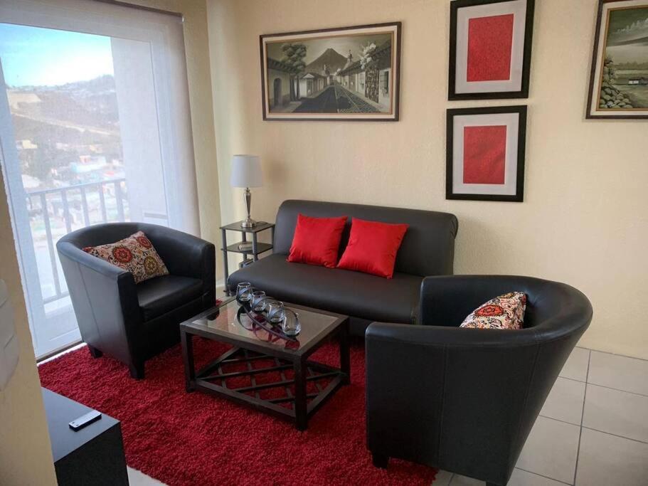un soggiorno con divano e 2 sedie di Cozy and relaxing apartment a Guatemala
