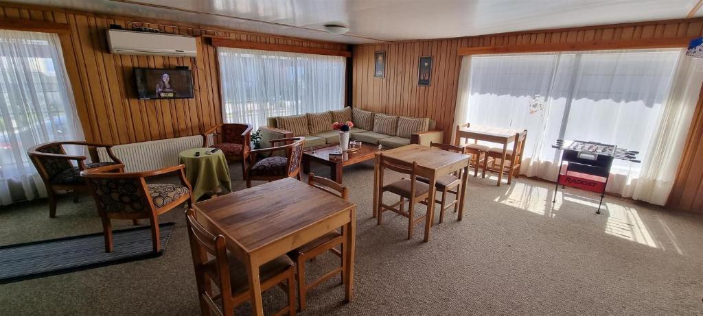 ein Wohnzimmer mit Stühlen, einem Tisch und einem Sofa in der Unterkunft Hostal Prat II in Valdivia