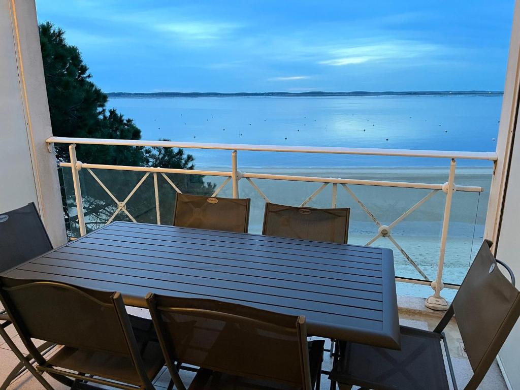 une table et des chaises sur un balcon avec vue sur l'océan dans l'établissement Appartement T3 en bord de mer avec balcon, WIFI et parking sécurisé - FR-1-374-23, à Arcachon