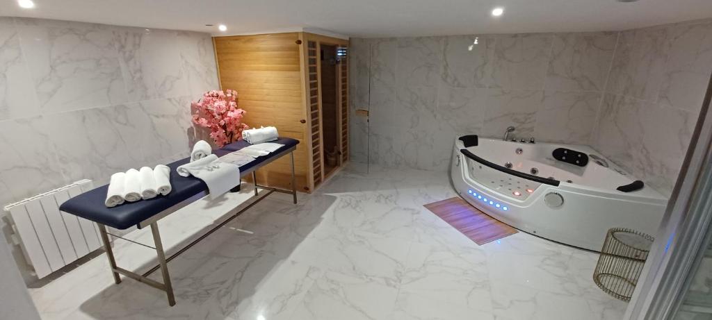 une salle de bain avec une baignoire et un lavabo dans l'établissement Magnifique loft jacuzzi et sauna Lanester-Lorient, à Lanester