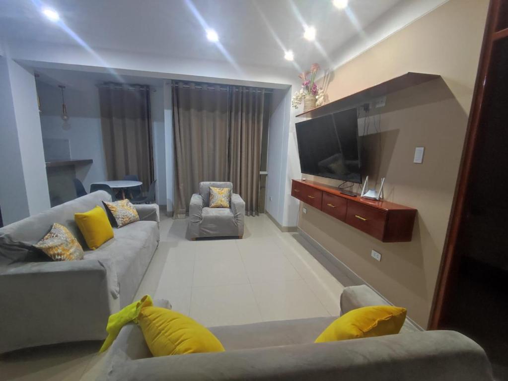 Il comprend un salon avec des canapés et une télévision à écran plat. dans l'établissement Soto Apartamentos, à Chiclayo