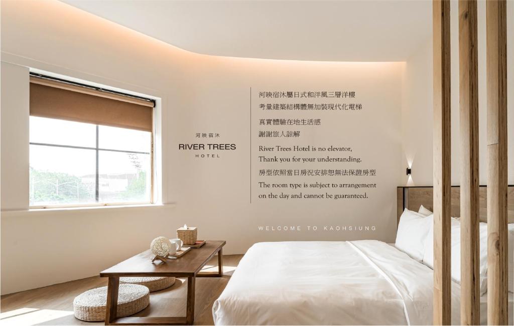 a bedroom with a bed and a writing on the wall at 河映宿沐 River Trees Hotel in Kaohsiung