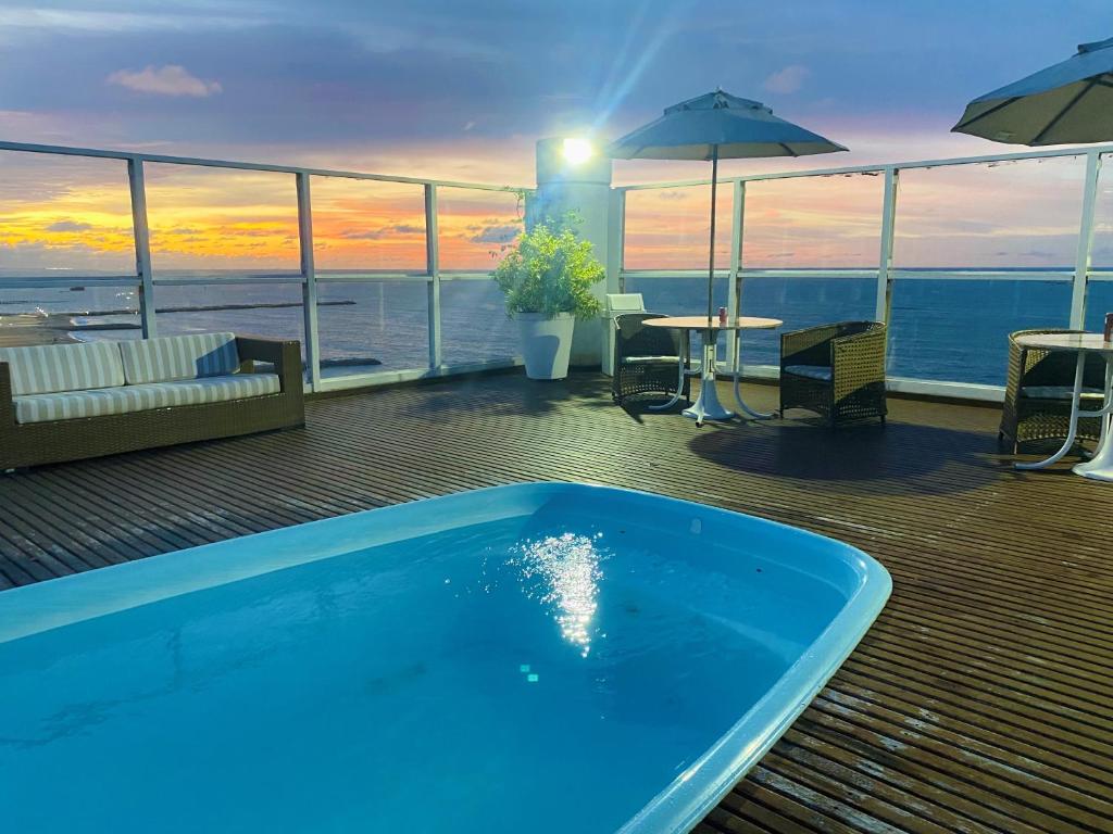 a swimming pool on a deck with a view of the ocean at Hotel na Beira Mar de Fortaleza - Vista Mar in Fortaleza