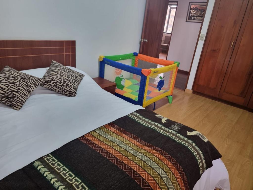 een slaapkamer met een bed en een kleurrijke wieg bij Advocatus’ Flat in Cuenca