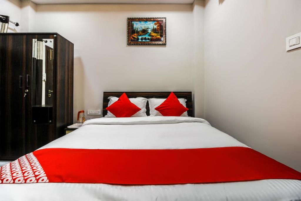 ein Schlafzimmer mit einem großen Bett mit roten Kissen in der Unterkunft OYO Shiva Guest House in Kamakhya