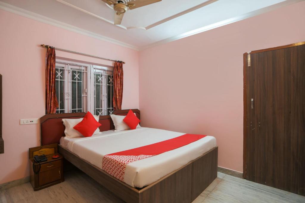 a bedroom with a bed with red pillows at OYO Ma Kali Guest House Near City Centre Salt Lake in Salt Lake City