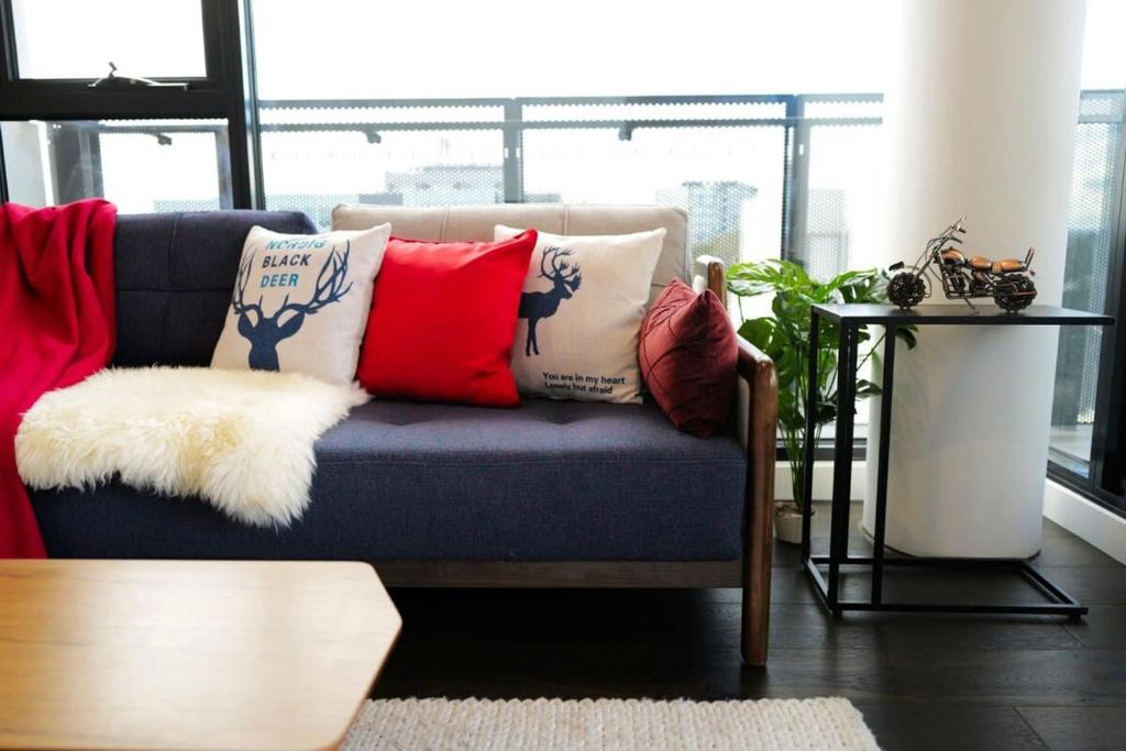 un sofá con almohadas en la sala de estar en Lovely Home in midtown Box Hill with two bedrooms, en Box Hill