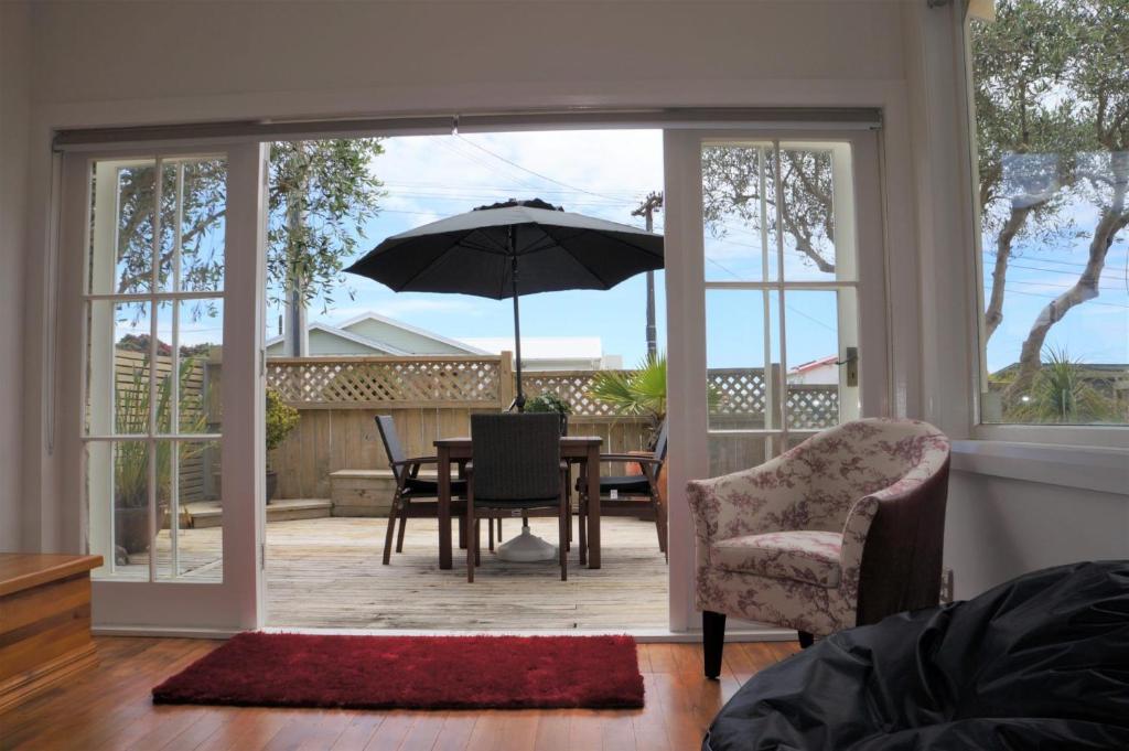 a living room with a table and an umbrella at The Buller Bungalow You Will Fall In Love in New Plymouth