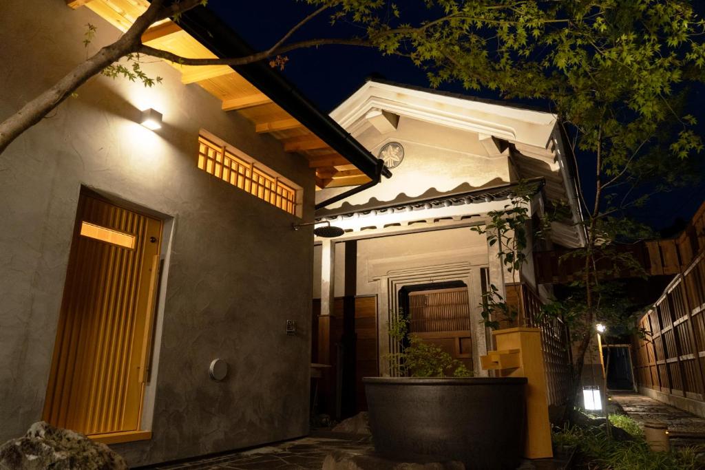 une maison avec une horloge sur son côté la nuit dans l'établissement 海野宿一棟貸し宿 上州屋 Unnojuku Joshuya, à Tomi