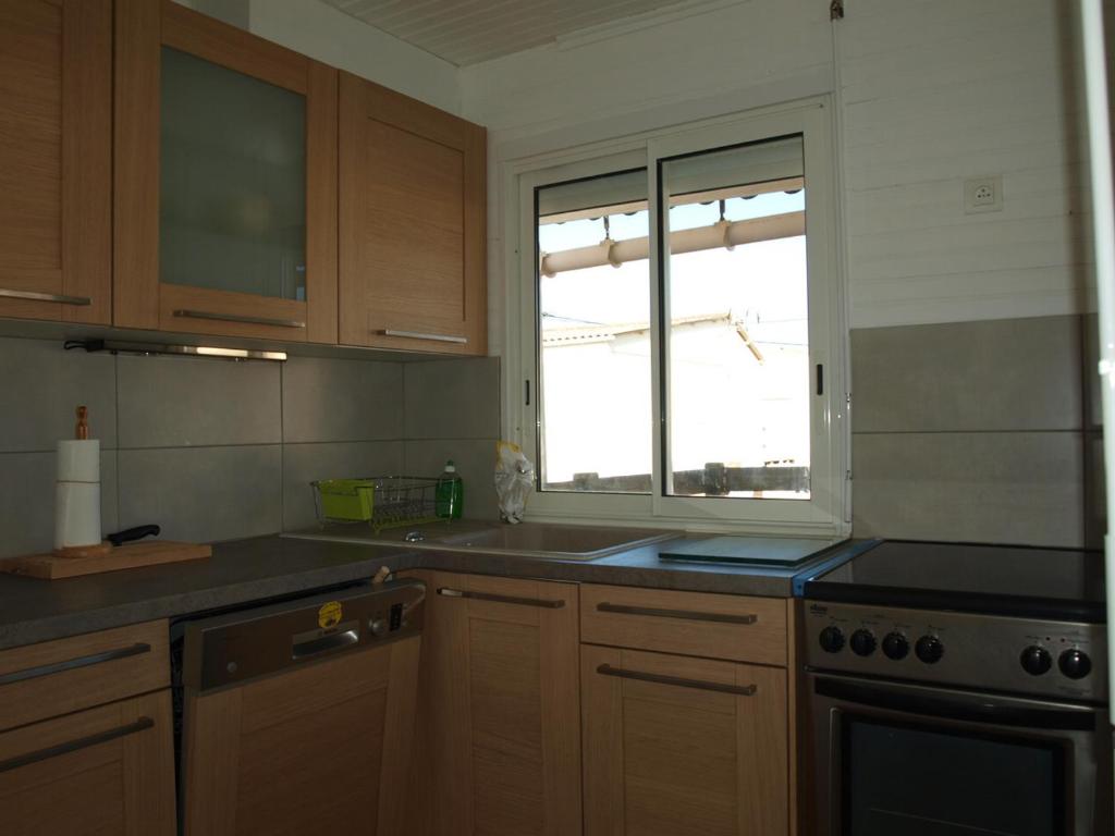une cuisine avec un évier et une fenêtre dans l'établissement Chalet familial 4 ch. à 100m de la mer - Terrasse - FR-1-784-2, à Gruissan