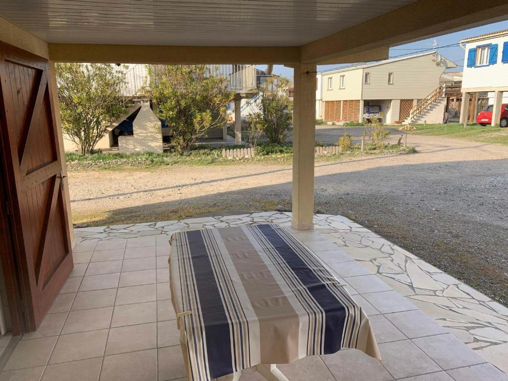 - une terrasse couverte avec un canapé dans l'établissement Chalet cosy à 400m de la plage avec terrasse et parking - 2 chambres, 4 pers. - FR-1-784-17, à Gruissan