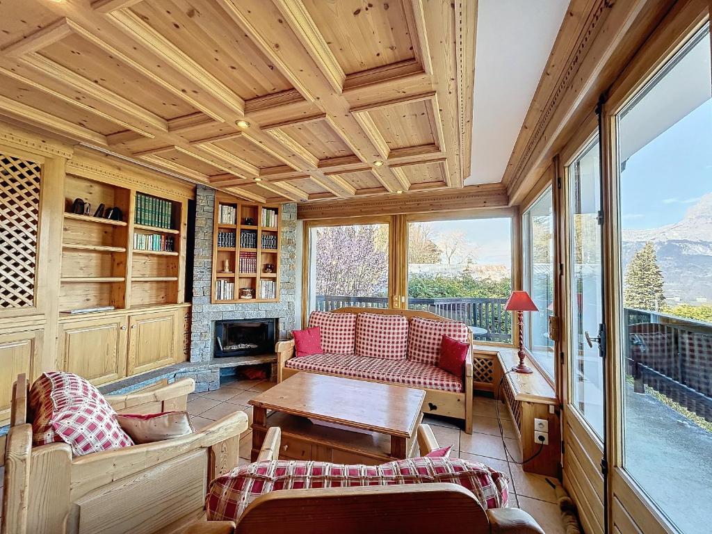 コンブルーにあるChalet 9 personnes à Combloux, Mont Blanc - FR-1-560-125のテーブルと椅子が置かれた網戸付きのポーチ