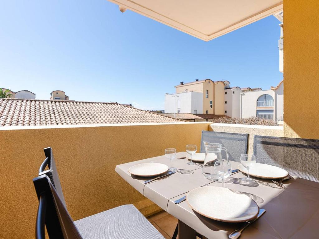 une table avec des chaises et des verres sur un balcon dans l'établissement Studio double cabine avec piscine, proche plage et commerces à Gruissan - FR-1-409A-29, à Gruissan
