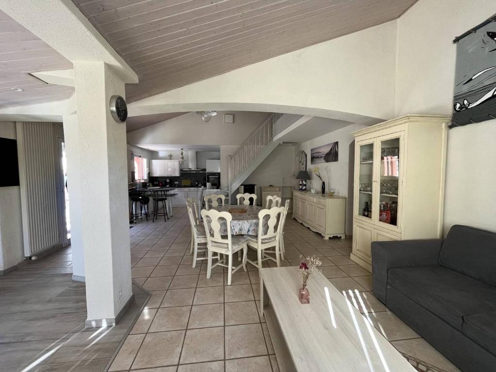 une cuisine et un salon avec une table et des chaises dans l'établissement Grande Maison 12 Pers. avec Terrasse, Proche Plage et Forêt, Animaux Admis - FR-1-324A-61, à Saint-Jean-de-Monts