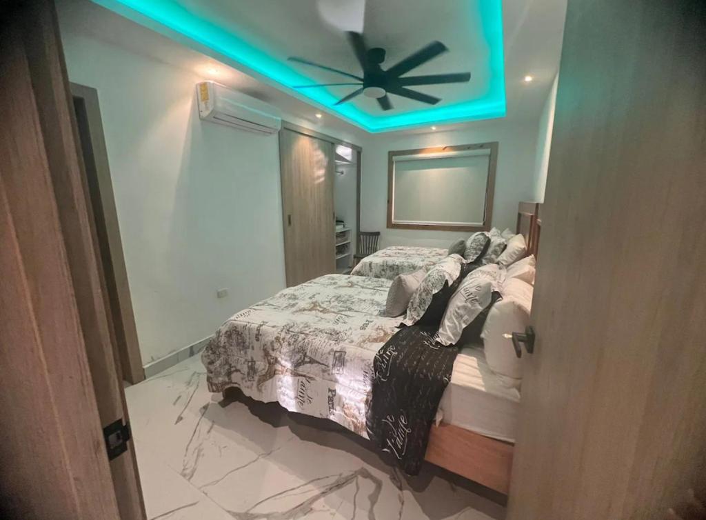 een slaapkamer met een bed en een plafondventilator bij Villa Génesis in Cabrera
