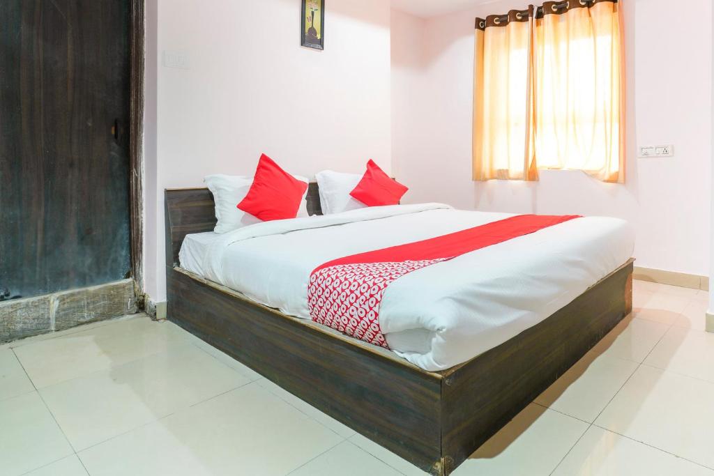 a bedroom with a bed with red pillows on it at SPOT ON Hotel Sunshine Inn in Hyderabad