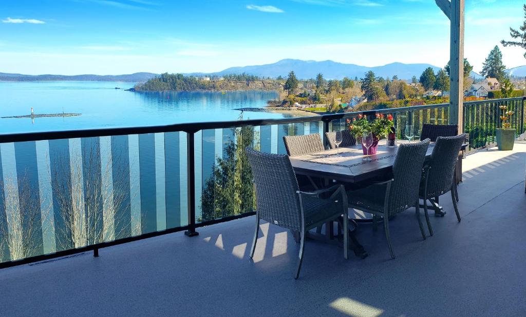a table and chairs on a balcony with a view of a lake at EdgeWater Chemainus in Chemainus
