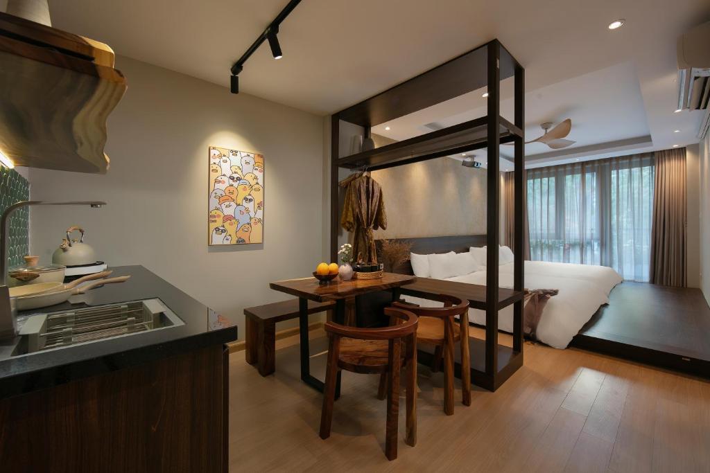 cocina y comedor con mesa y cama en Brilliant Nature Suites & Spa, en Hanói