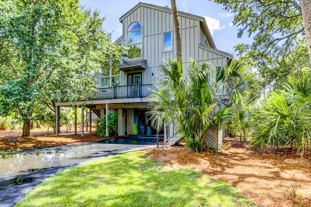 een groot huis met een balkon en bomen bij Oceanwood 112 in Hilton Head Island