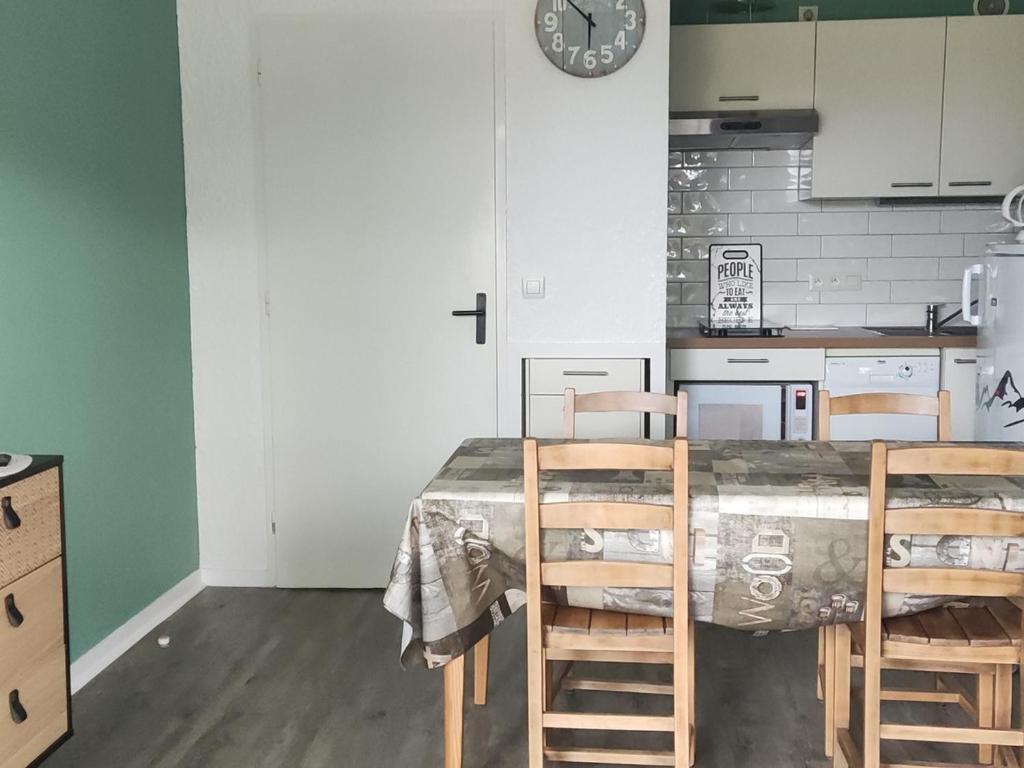 奥特朗Appartement rénové 4 pers, proche pistes, balcon sud, Autrans - FR-1-737-80的带桌椅和钟的厨房