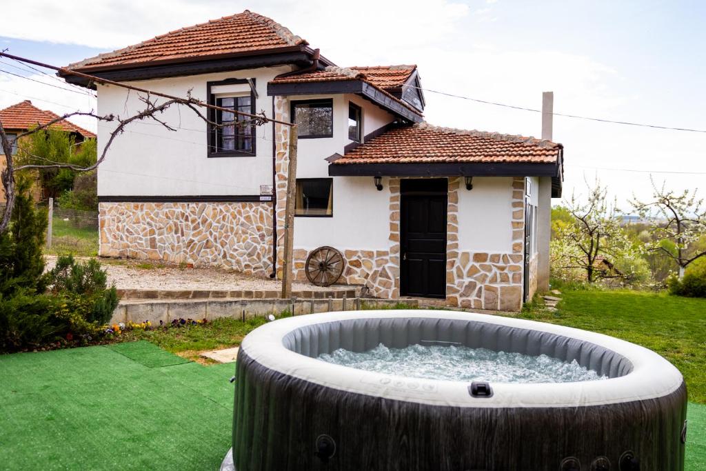 ein Haus mit einem großen Wasserbecken im Hof in der Unterkunft СТАРАТА КЪЩА in Sovolyano