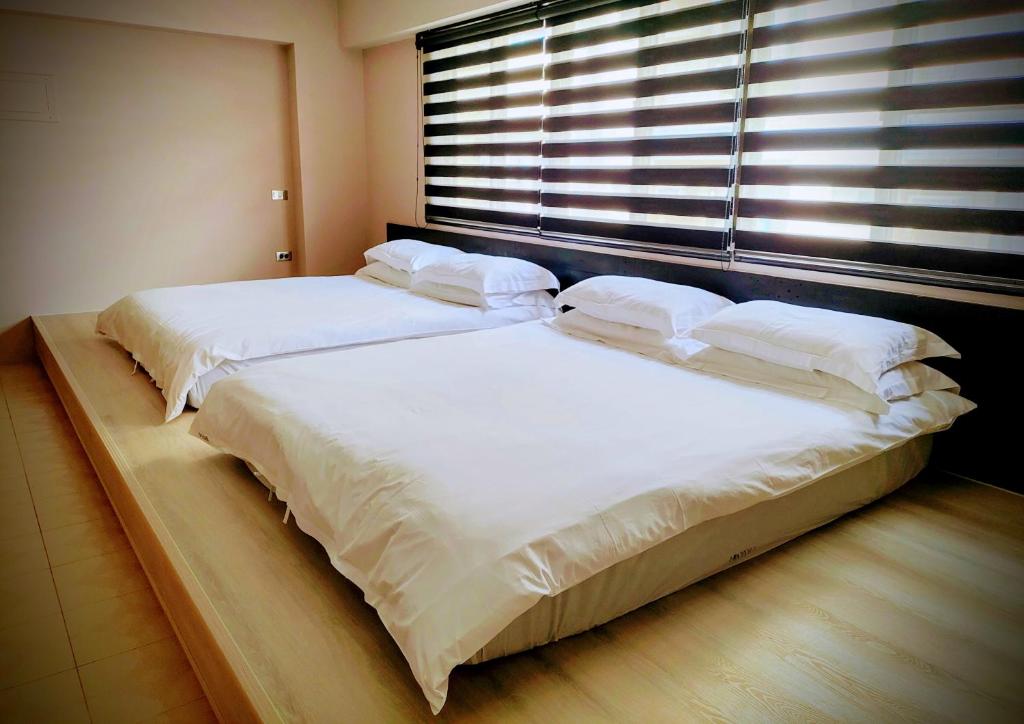 台南的住宿－小步洋樓，卧室的窗户旁设有两张床