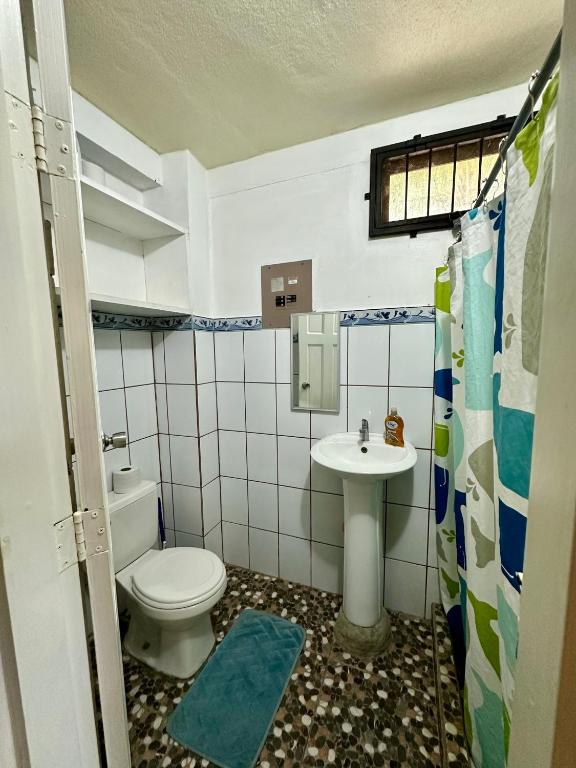 a small bathroom with a toilet and a sink at Frente la playa Isis in Sámara