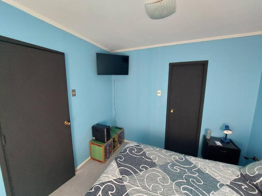 - une chambre dotée d'un lit avec un mur bleu dans l'établissement Departamento En Centro Turístico De Valparaíso, à Valparaíso