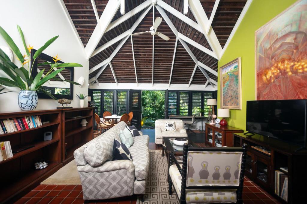 a living room with a couch and a tv at Tardis Rose Cottage w/rental vehicle access in Cap Estate