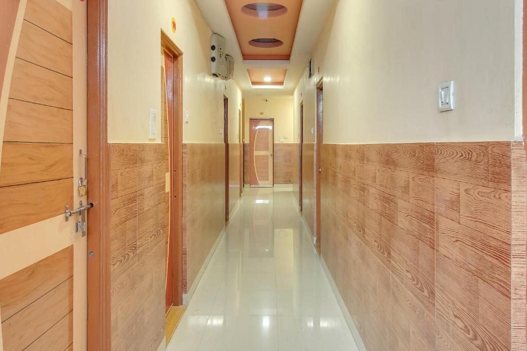 a long hallway with wooden walls and a hallway with a door at OYO Hotel Abhijeet in Chikalthān