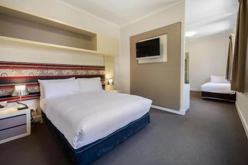 a hotel room with a large bed and a television at Best Western Melbourne City in Melbourne