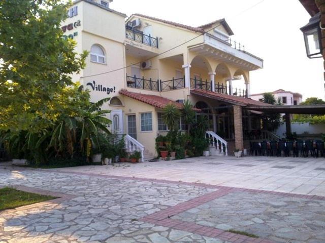 a large white building with a patio in front of it at The Village in Igoumenitsa
