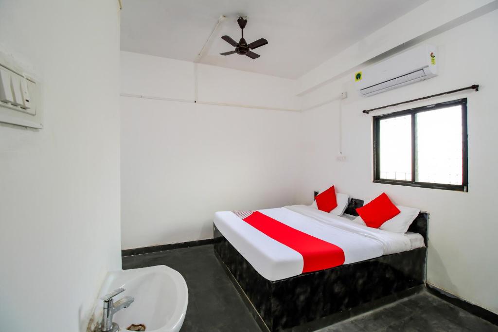 biała sypialnia z łóżkiem i umywalką w obiekcie OYO Flagship 69410 Sip & Bite Restaurant N Lodging w mieście Mansar