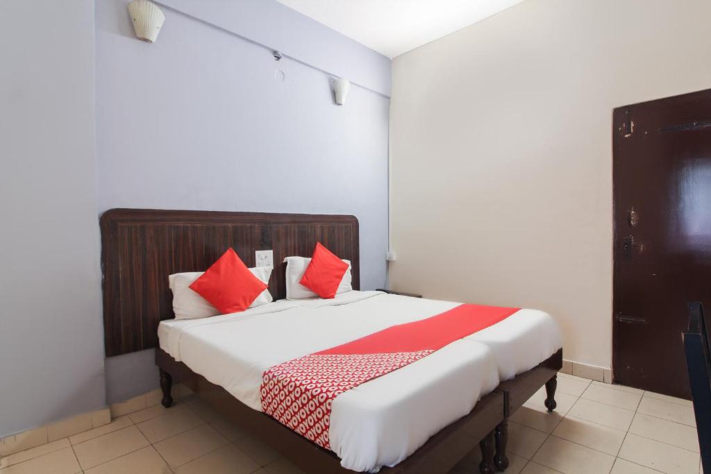 a bedroom with a large bed with red pillows at OYO Hotel Regal Near Paradise Circle in Secunderabad