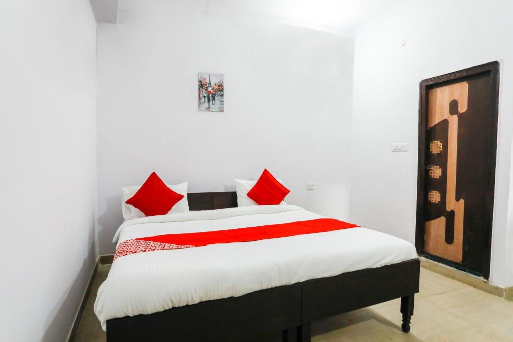 um quarto com uma cama com almofadas vermelhas em OYO Hindon Residency em Ghaziabad