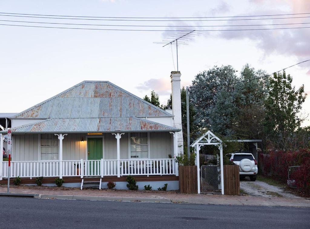 a white house with a car parked in front of it at Mill Cottage in Tenterfield