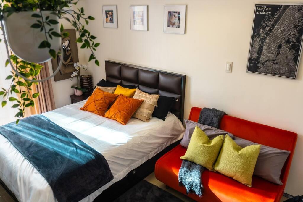 Un dormitorio con una cama con almohadas de colores. en Flexi-Living Premium Condo in Kasara en Manila