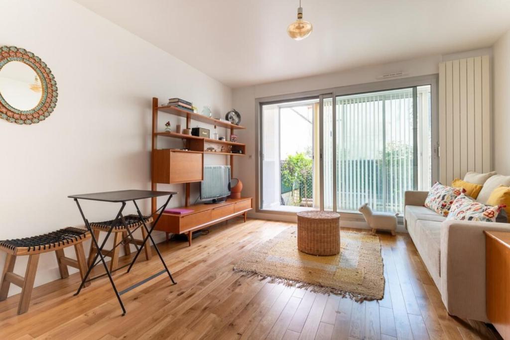 un salon avec un canapé et une table dans l'établissement Urban & Stylish Apartment w GardenNation, à Paris
