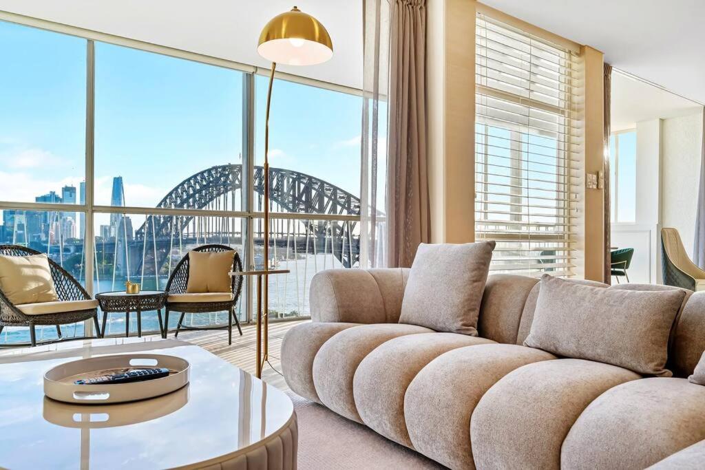 - un salon avec un canapé et une grande fenêtre dans l'établissement Sydney's Landmark Views from Luxury 2Bd Apt, à Sydney