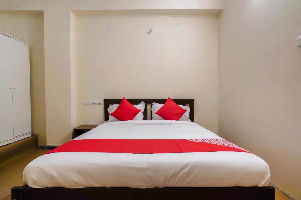 a bedroom with a large bed with red pillows at Alpine glow Zenith in Hyderabad