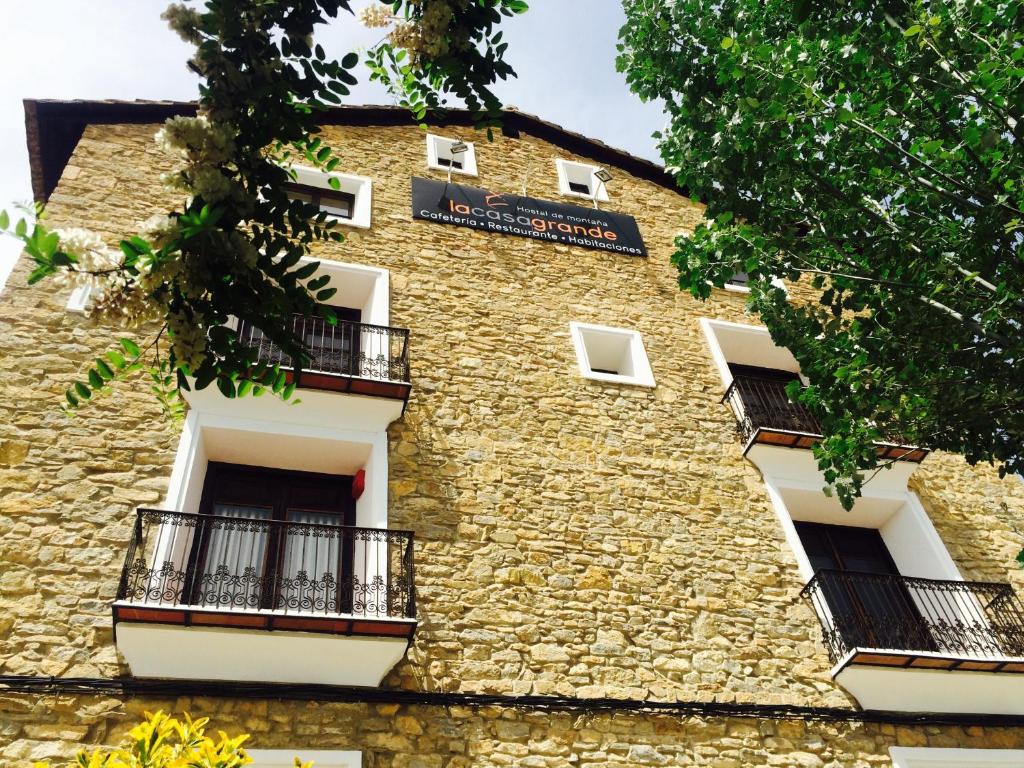 un edificio de ladrillo con balcones y una señal en él en Hostal de Montaña la Casa Grande en Nogueruelas