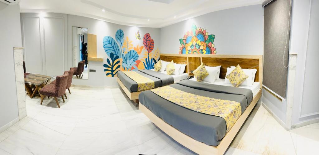 um quarto de hotel com duas camas e uma secretária em The Yes Please - Near New Delhi Railway Station- Paharganj em Nova Deli