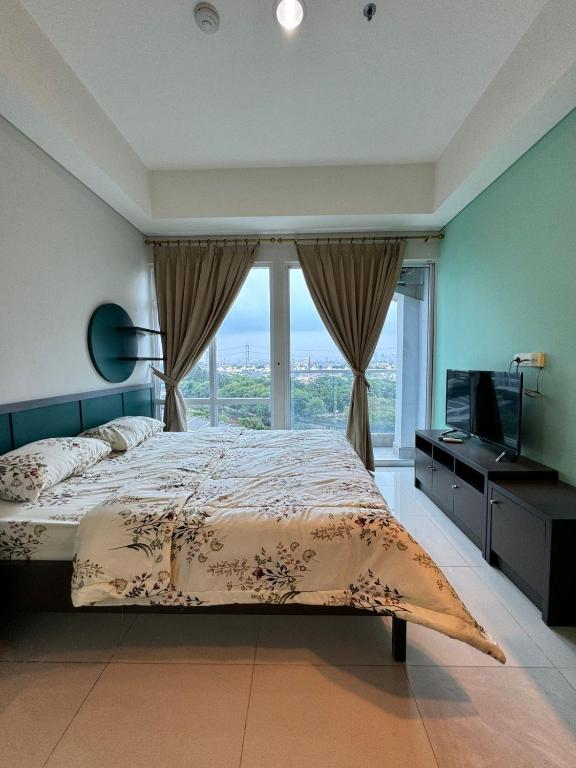 a bedroom with a bed and a large window at Apartemen Puri Mansion Cozy, Lokasi Strategis in Jakarta